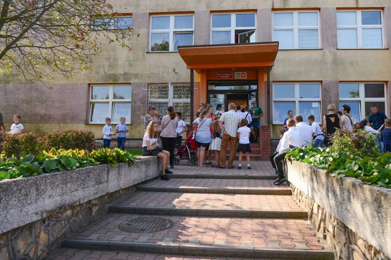 Uczniowie wchodzą do szkoły na rozpoczęcie roku szkolnego.