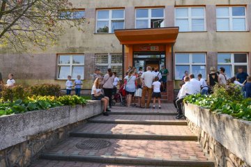 Uczniowie wchodzą do szkoły na rozpoczęcie roku szkolnego.