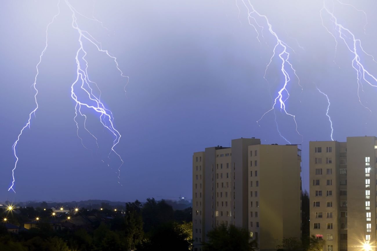 Piorun na niebie, miasto, wysokie bloki.