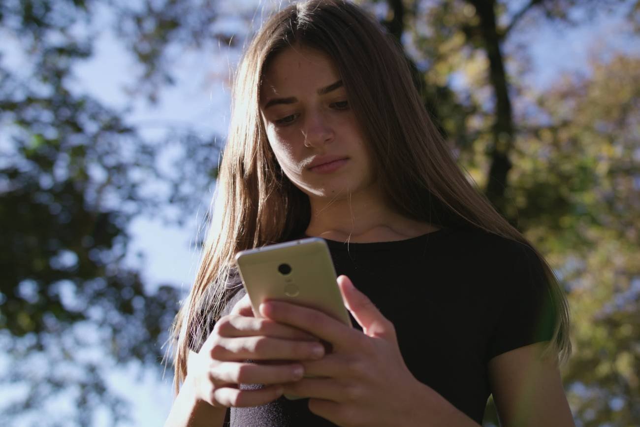 Nastolatka wpatrzona w smartfona.