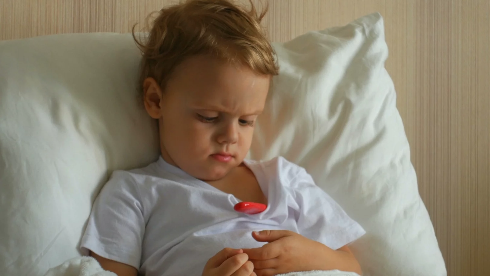 Dziecko często choruje – co może być tego przyczyną? Na zdjęciu dziecko leży w łóżku z termometrem.