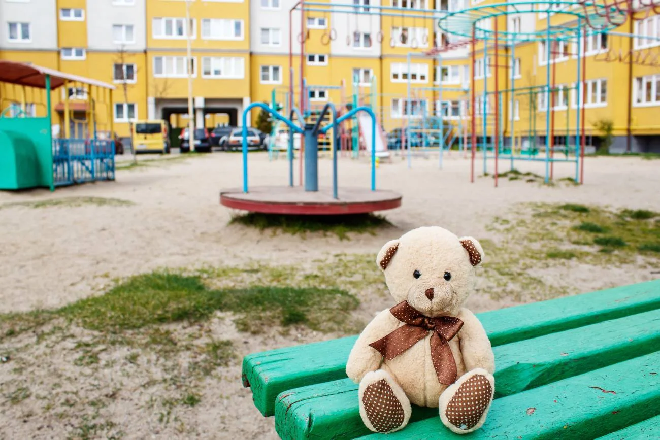 Miś przytulanka na przedszkolnym placu zabaw.