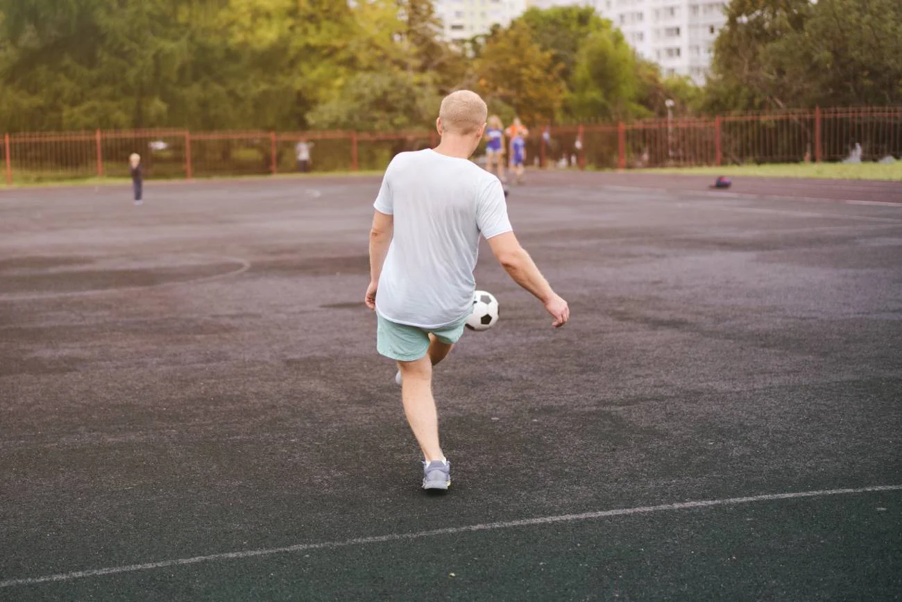 Chłopak na obozie sportowym gra w piłkę nożną.