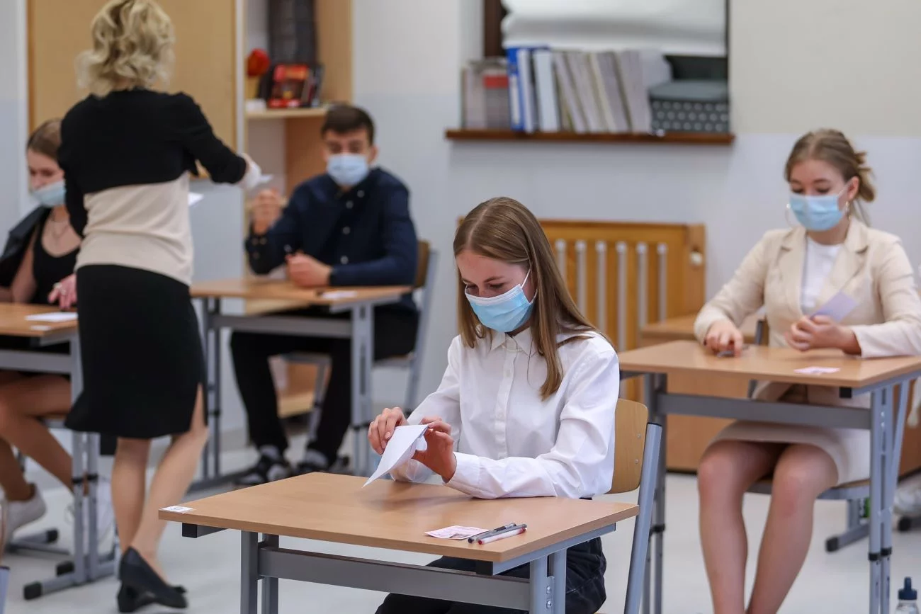 nauczycielka zwraca uwagę uczennicom na za krótkie spódnice