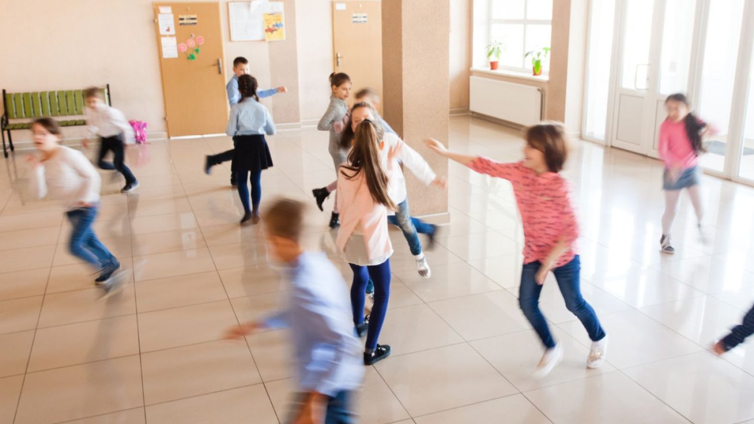 uczniowie biegający po korytarzu w czasie przerwy