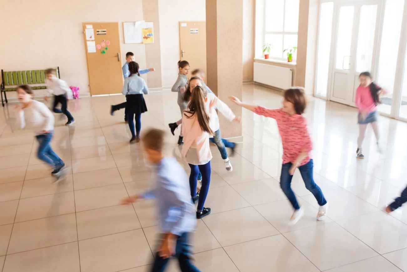 uczniowie biegający po korytarzu w czasie przerwy