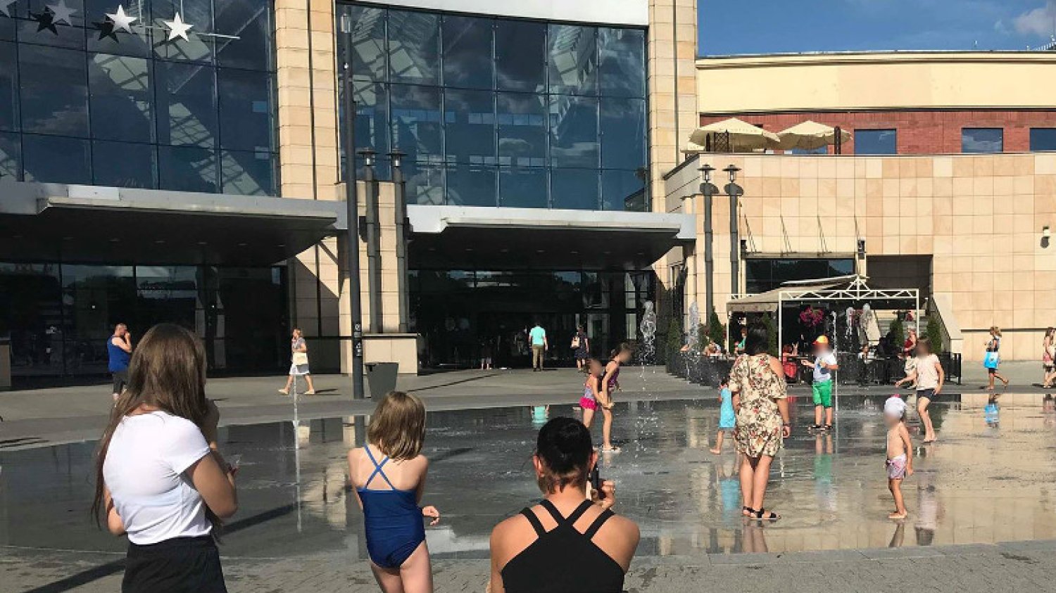 Dzieci kąpiące się w fontannie przed centrum handlowym