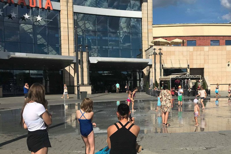 Dzieci kąpiące się w fontannie przed centrum handlowym