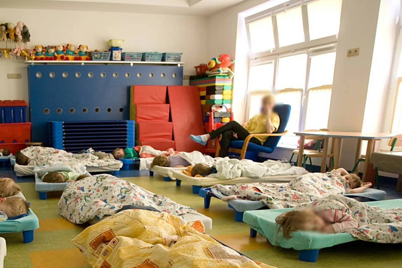 Dzieci w przedszkolu śpią na leżakowaniu.