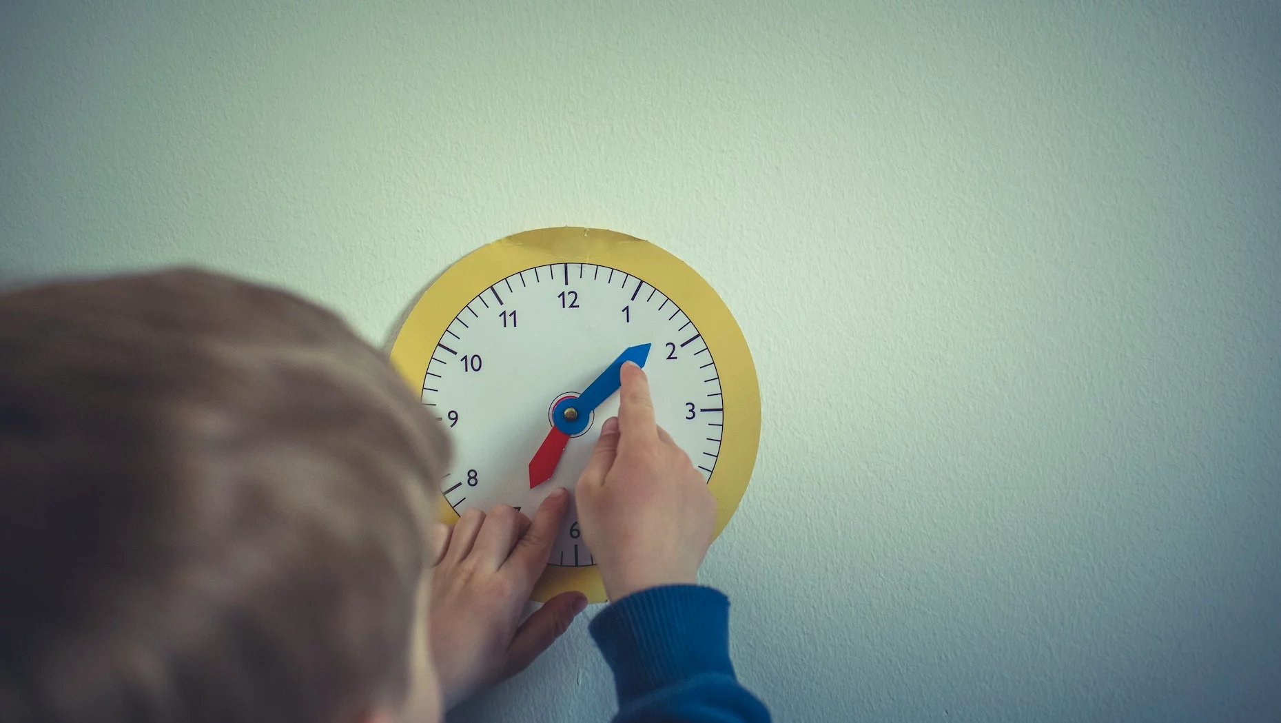 Na zdjęciu dziecko uczy się zegara.