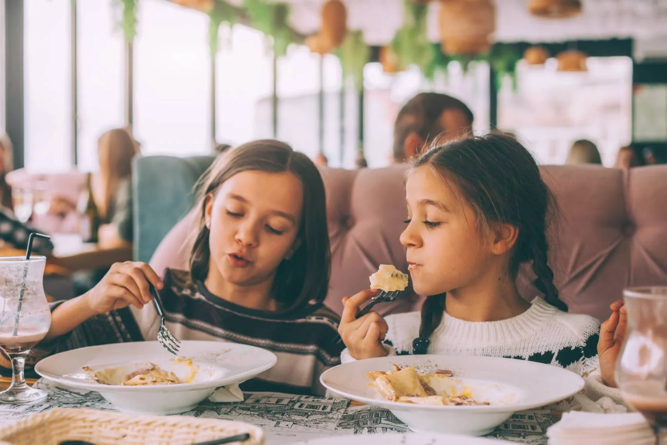 Dzieci w restauracji jedzą posiłki.