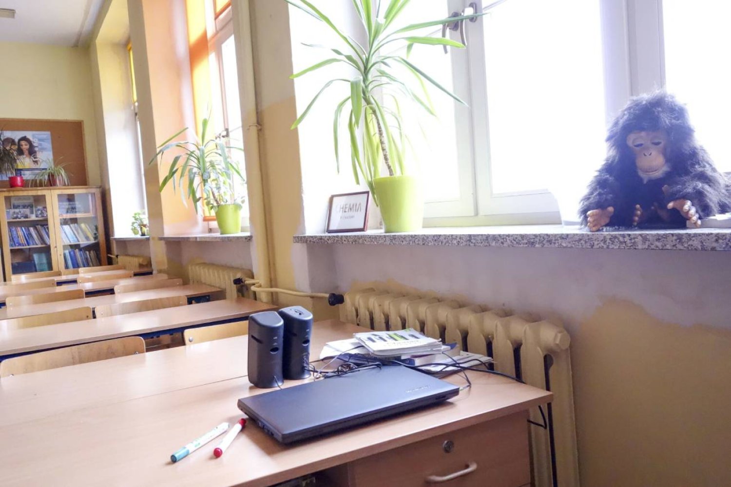 Szkolna klasa lekcyjna z laptopem na biurku do nauki zdalnej.