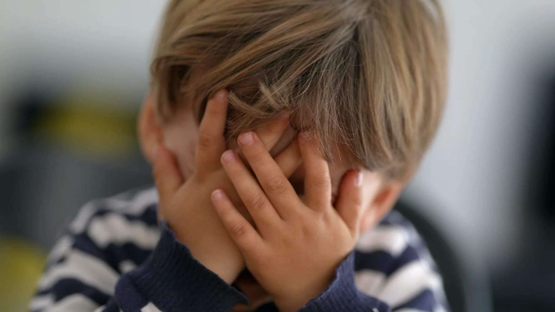 Nigdy nie zawstydzaj dziecka. To forma przemocy psychicznej. Na zdjęciu mały chłopiec zakrywa sobie twarz w geście zawstydzenia.