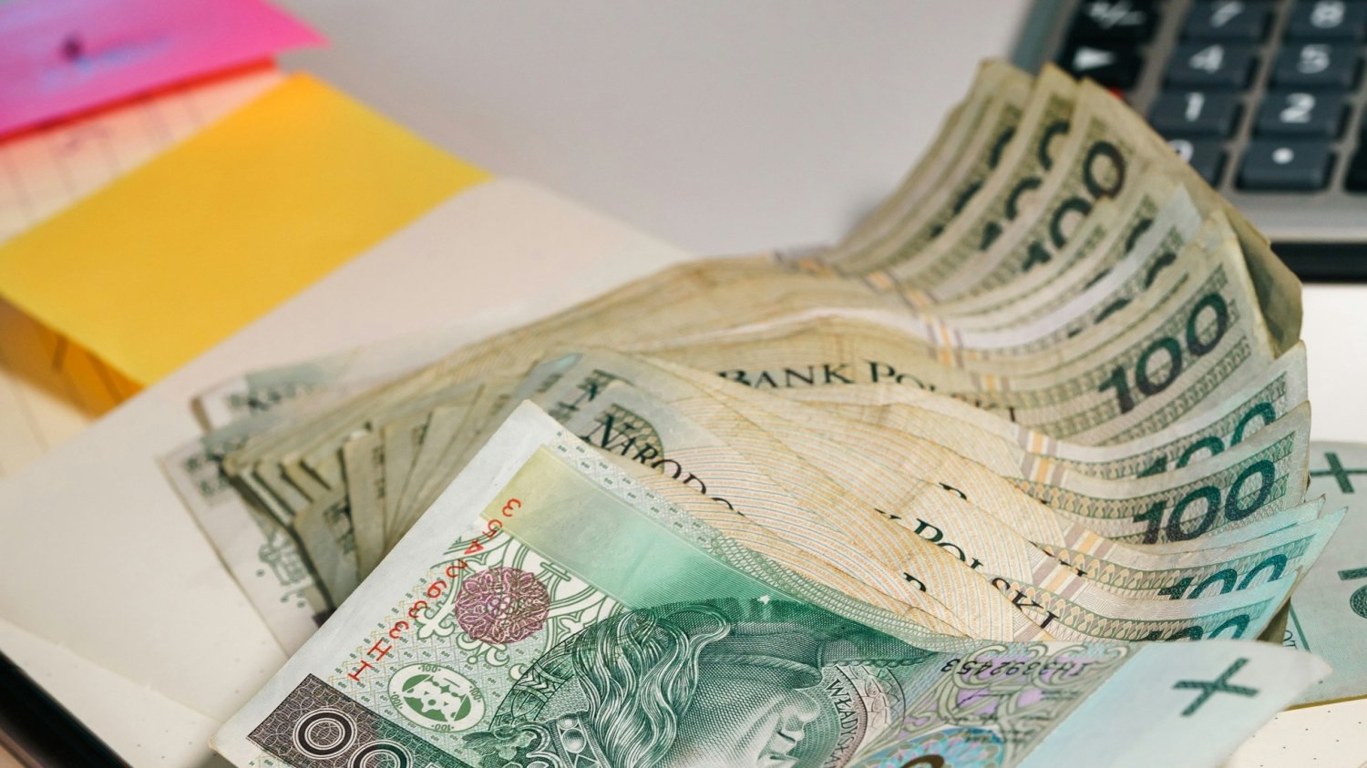 Na zdjęciu plik banknotów 100 zł