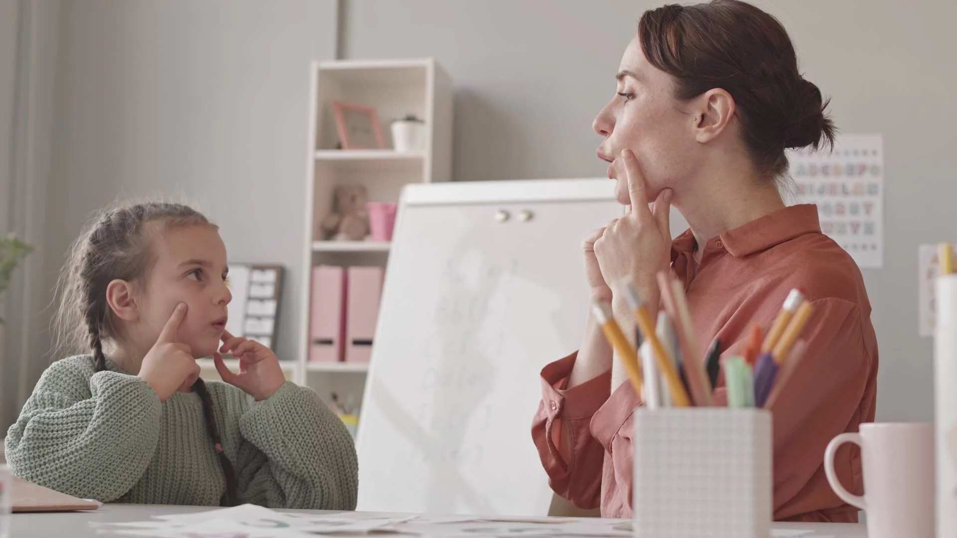 logopedka pracuje w gabinecie z dziewczynką logopedka pracuje w gabinecie z dziewczynką