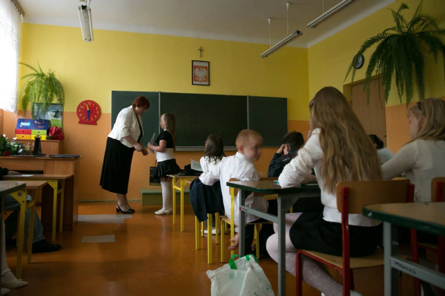 Wychowawczyni wręcza uczniom nagrody na zakończenie roku szkolnego.
