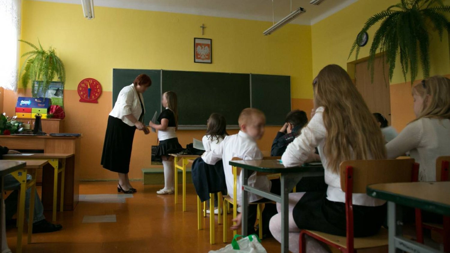 Wychowawczyni wręcza uczniom nagrody na zakończenie roku szkolnego.