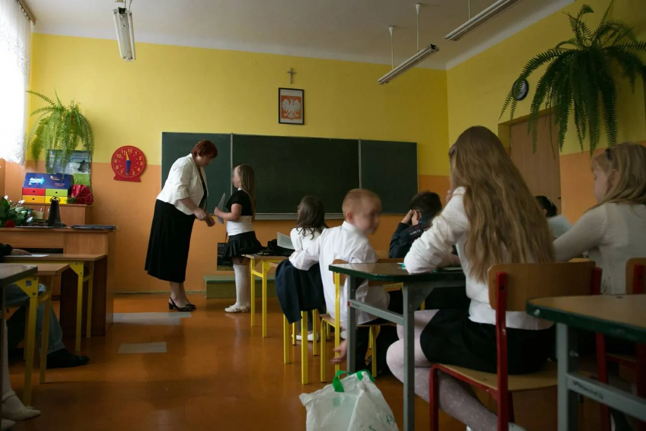 Wychowawczyni wręcza uczniom nagrody na zakończenie roku szkolnego.