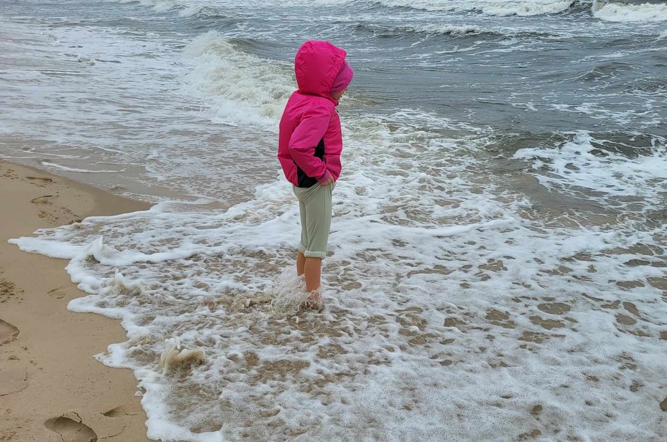 dziecko moczy nogi w Bałtyku