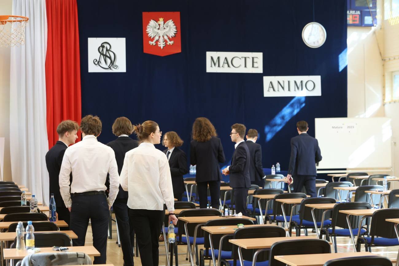 Maturzyści wychodzą z egzaminu maturalnego po napisaniu wypracowania.