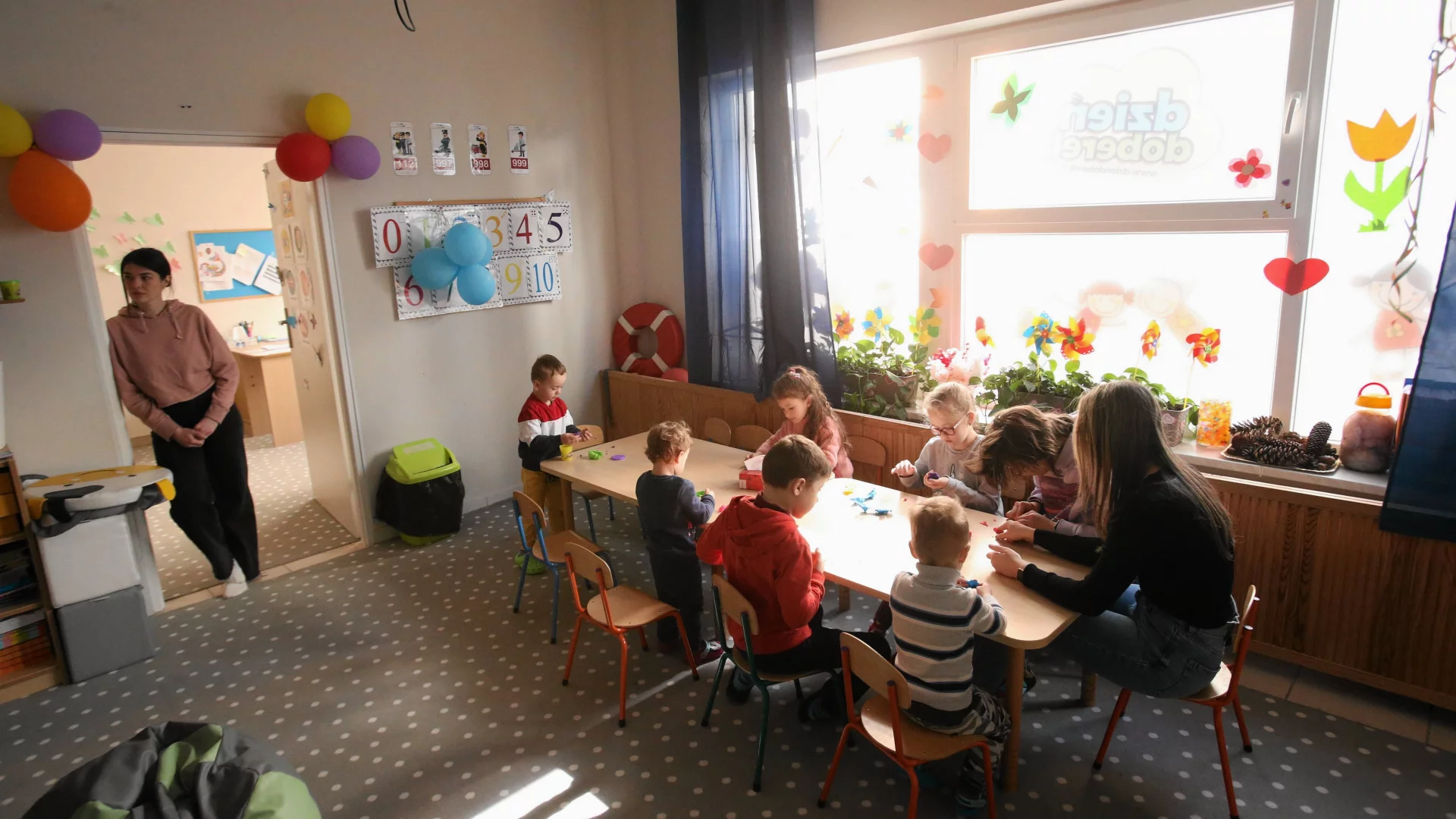 dzieci z nauczycielką w przedszkolnej sali