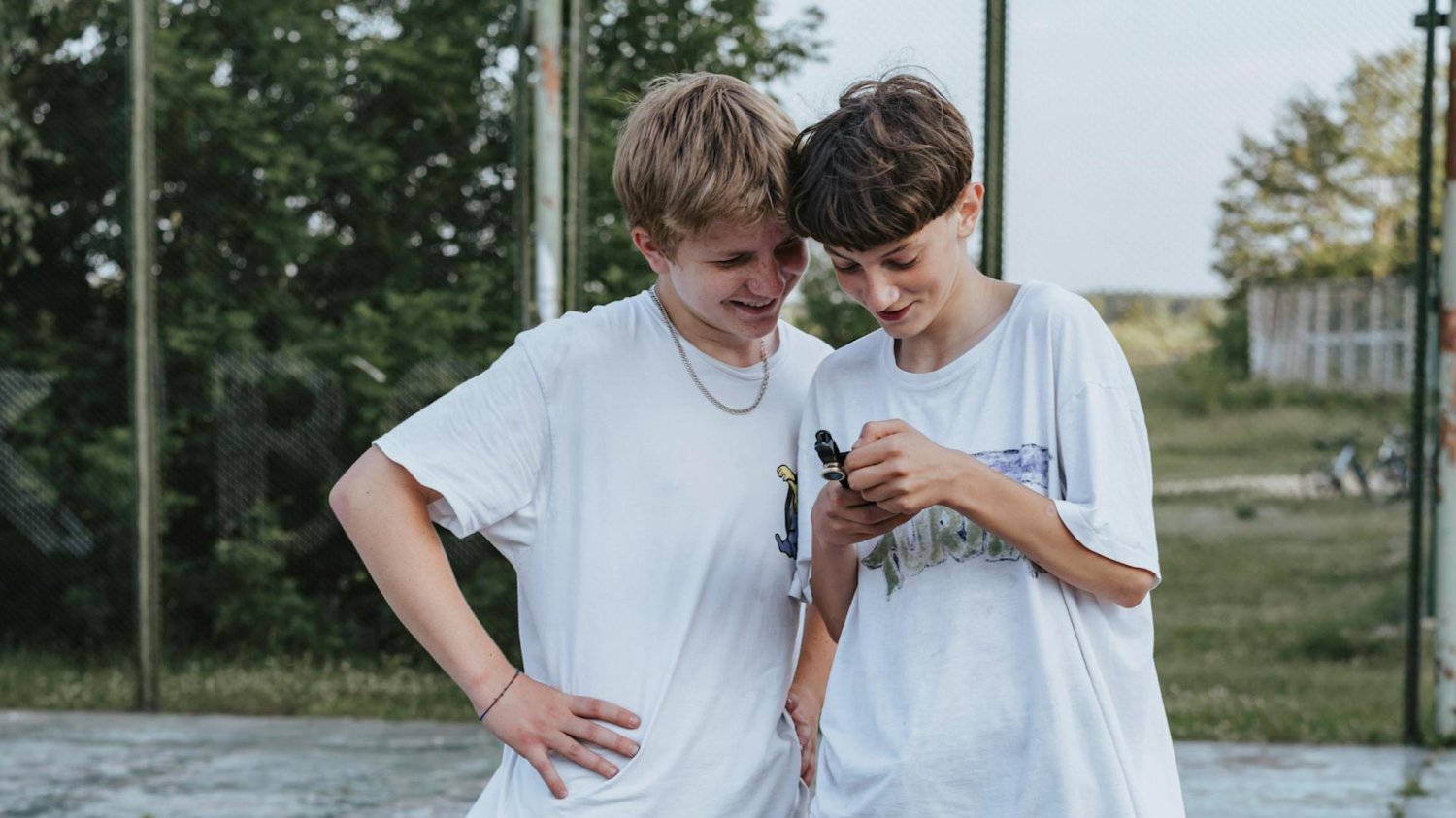nastolatkowie patrzą w telefon