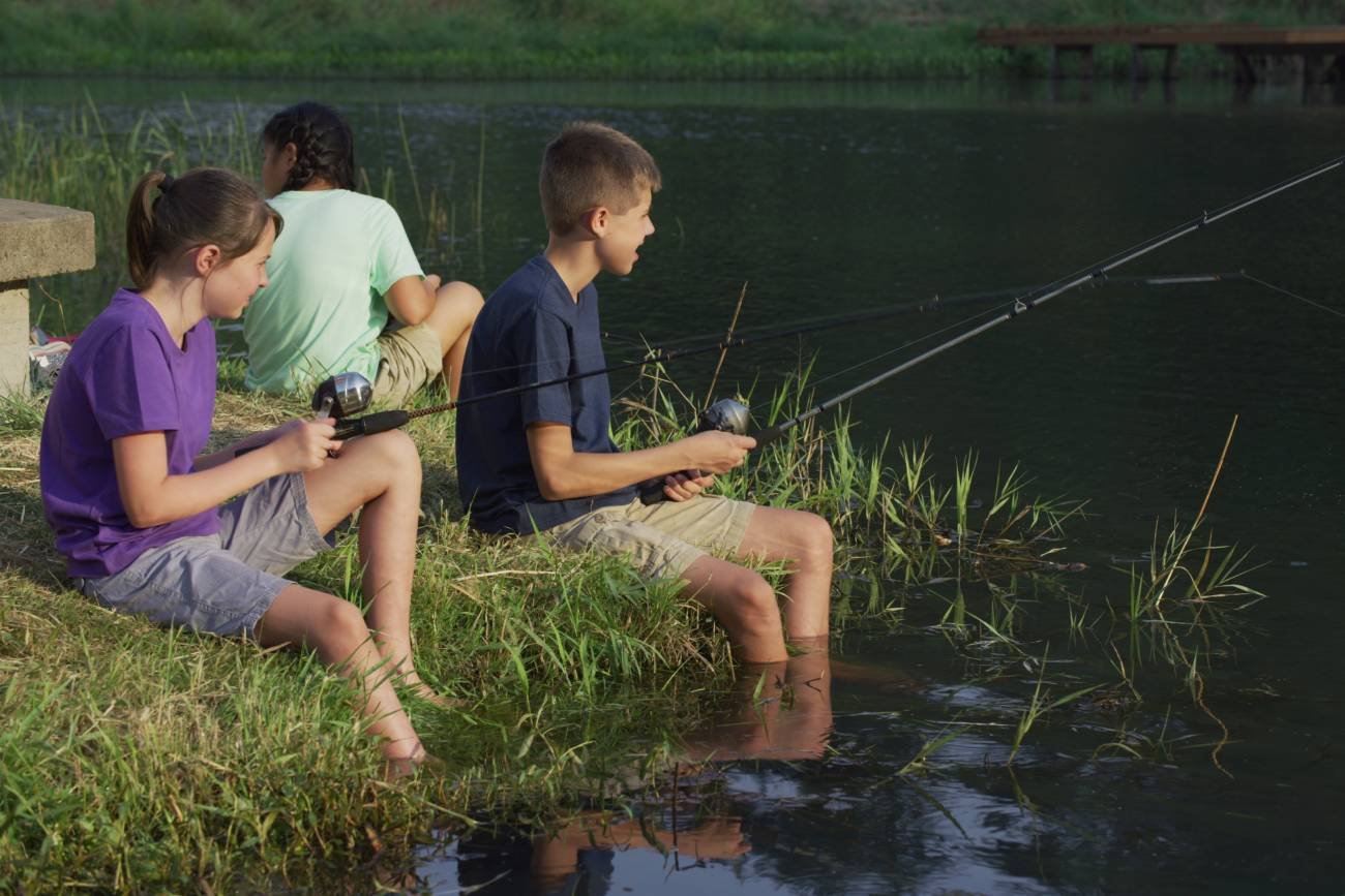 dzieci podczas obozu wakacyjnego łowią ryby dzieci podczas obozu wakacyjnego łowią ryby