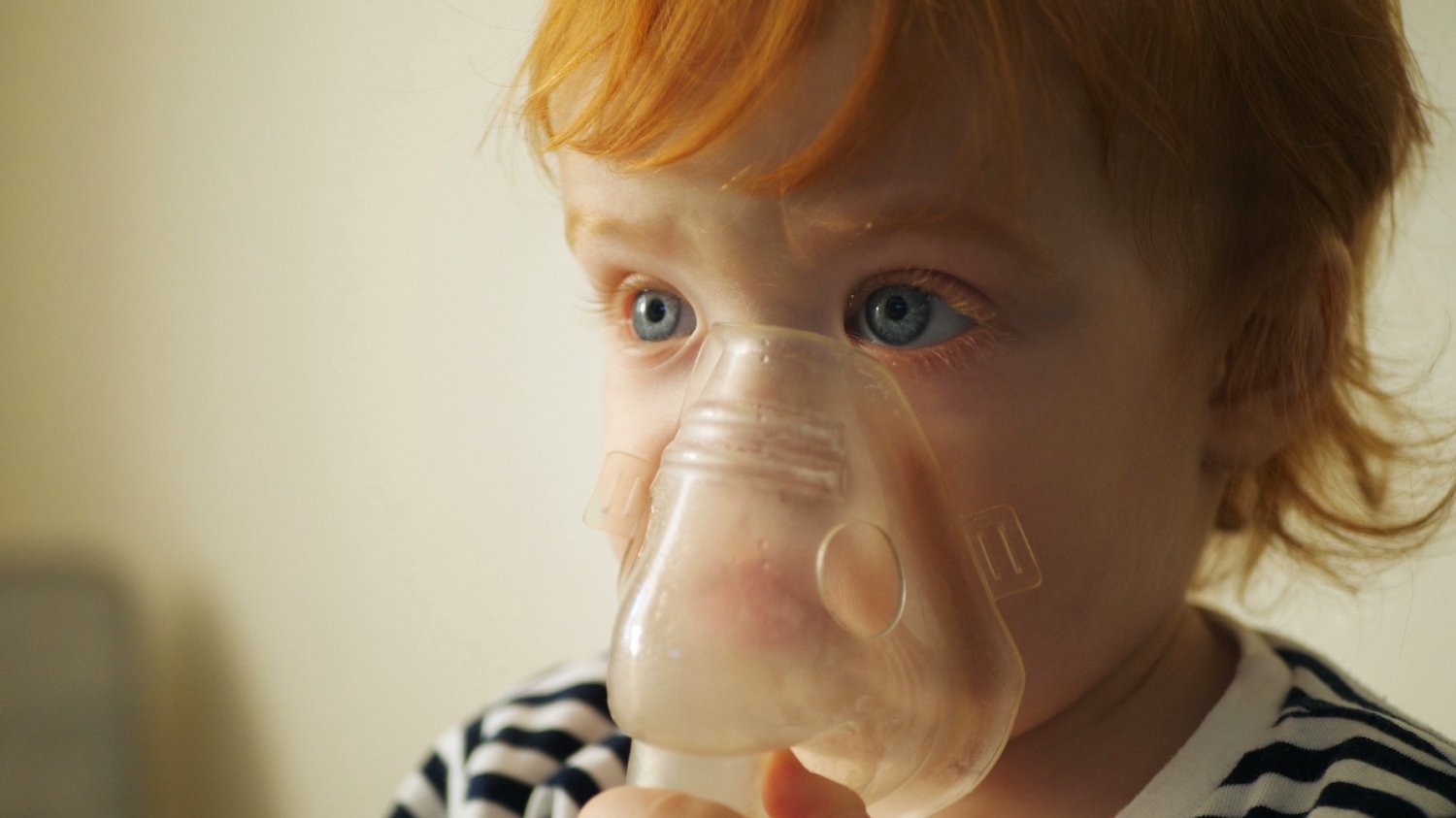 Na zdjęciu dziewczynka robi inhalacje w maseczce.