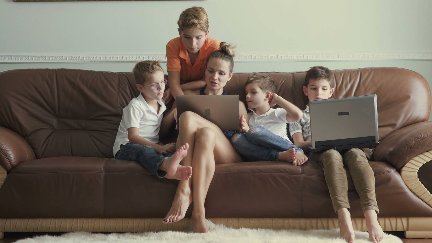 mama z dziećmi siedzą przed ekranami