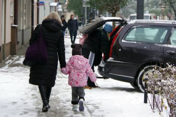 Kobieta idzie przez miasto z dzieckiem. Kobieta idzie przez miasto z dzieckiem.