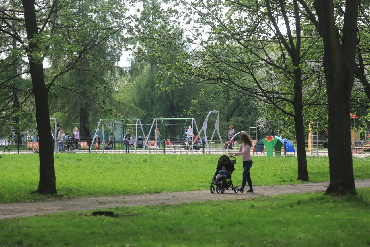 mama z dzieckiem idzie na plac zabaw w parku mama z dzieckiem idzie na plac zabaw w parku