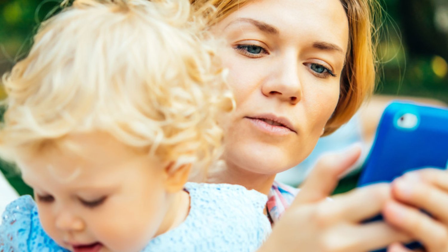 Mama używa telefonu podczas zabawy z dzieckiem