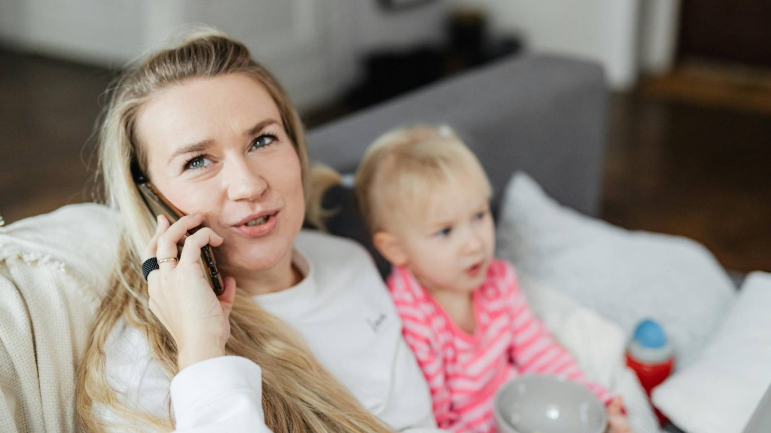 mama rozmawia przez telefon, zajmując się dzieckiem