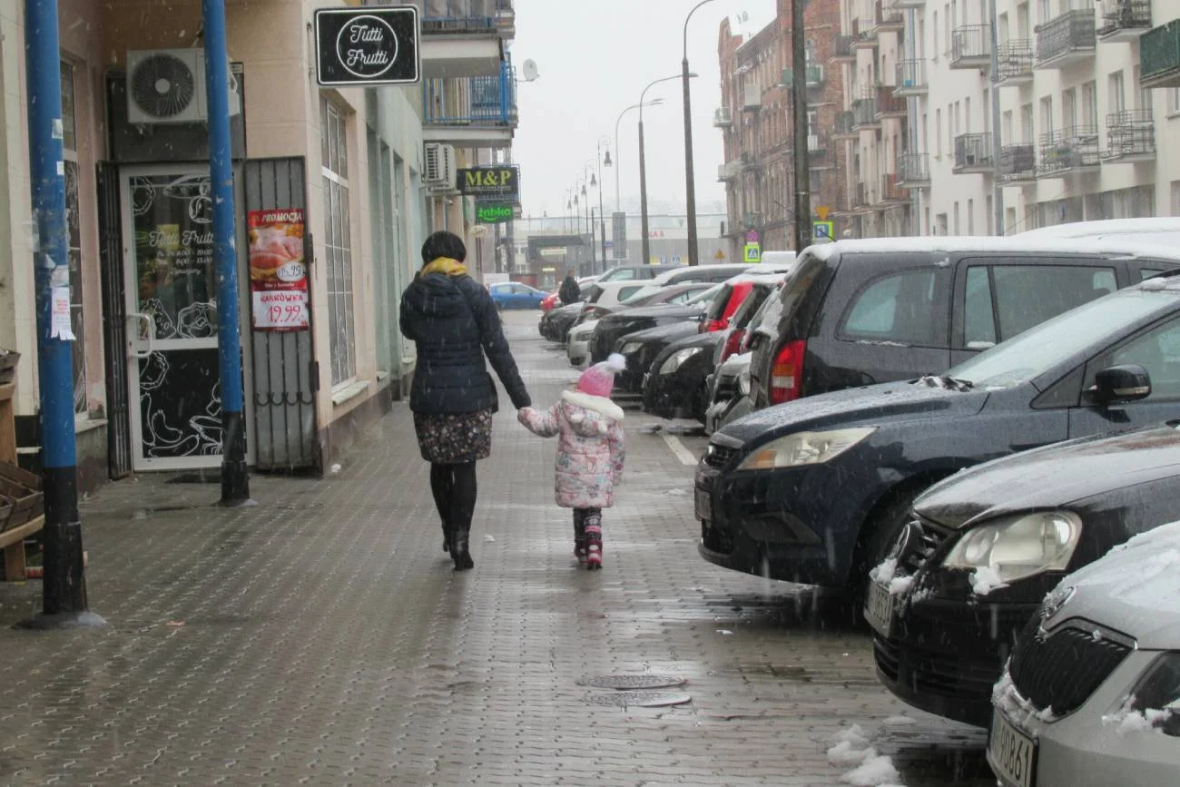 Kobieta idąca przez miasto z dzieckiem.