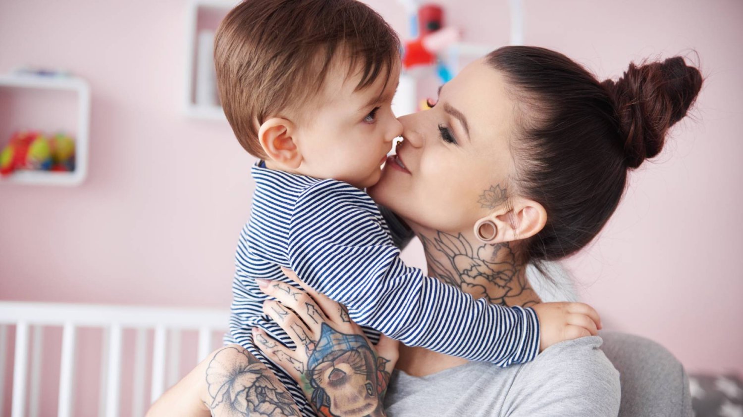 młoda mama trzyma małe dziecko na rękach i patrzy na nie młoda mama trzyma małe dziecko na rękach i patrzy na nie