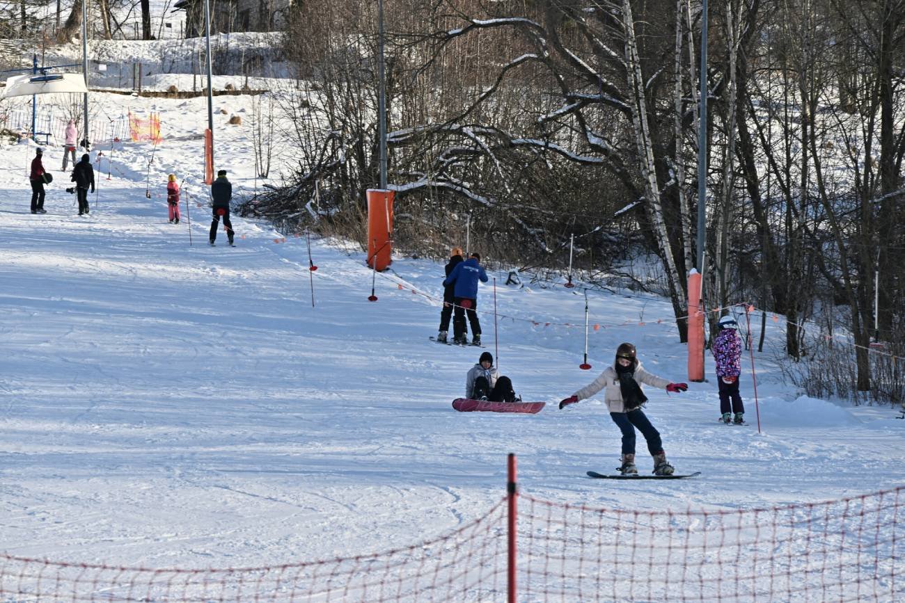 Uczniowie na białej szkole jeżdżą na stoku.