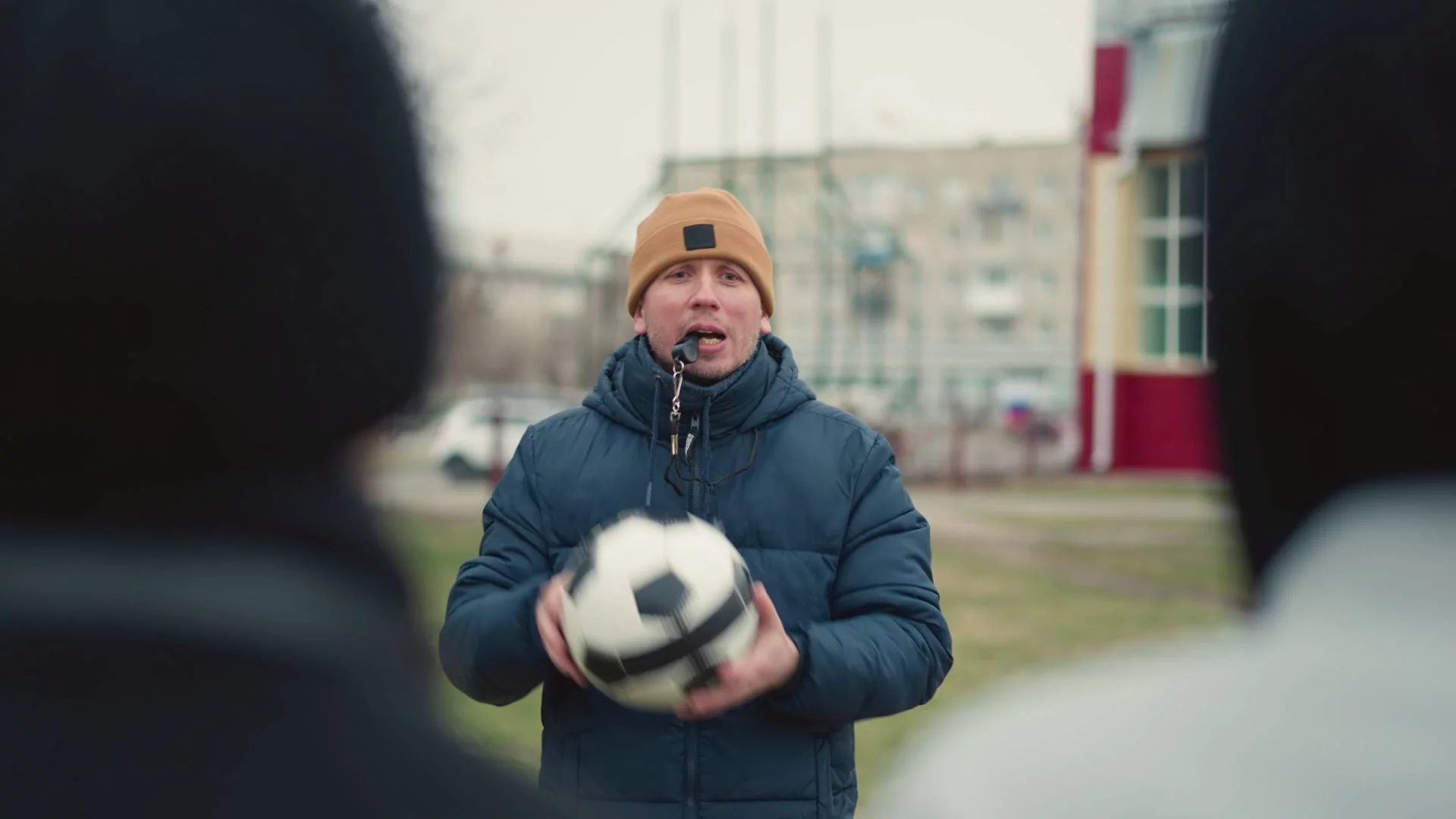 trener piłkarski na treningu mówi do dzieci