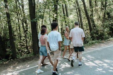 Grupa nastolatków rozmawia i idzie przez park.