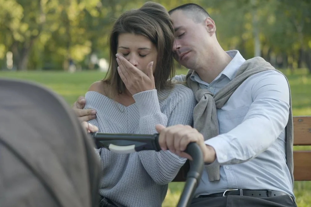 Na zdjęciu widać zmęczoną parę siedzącą w parku