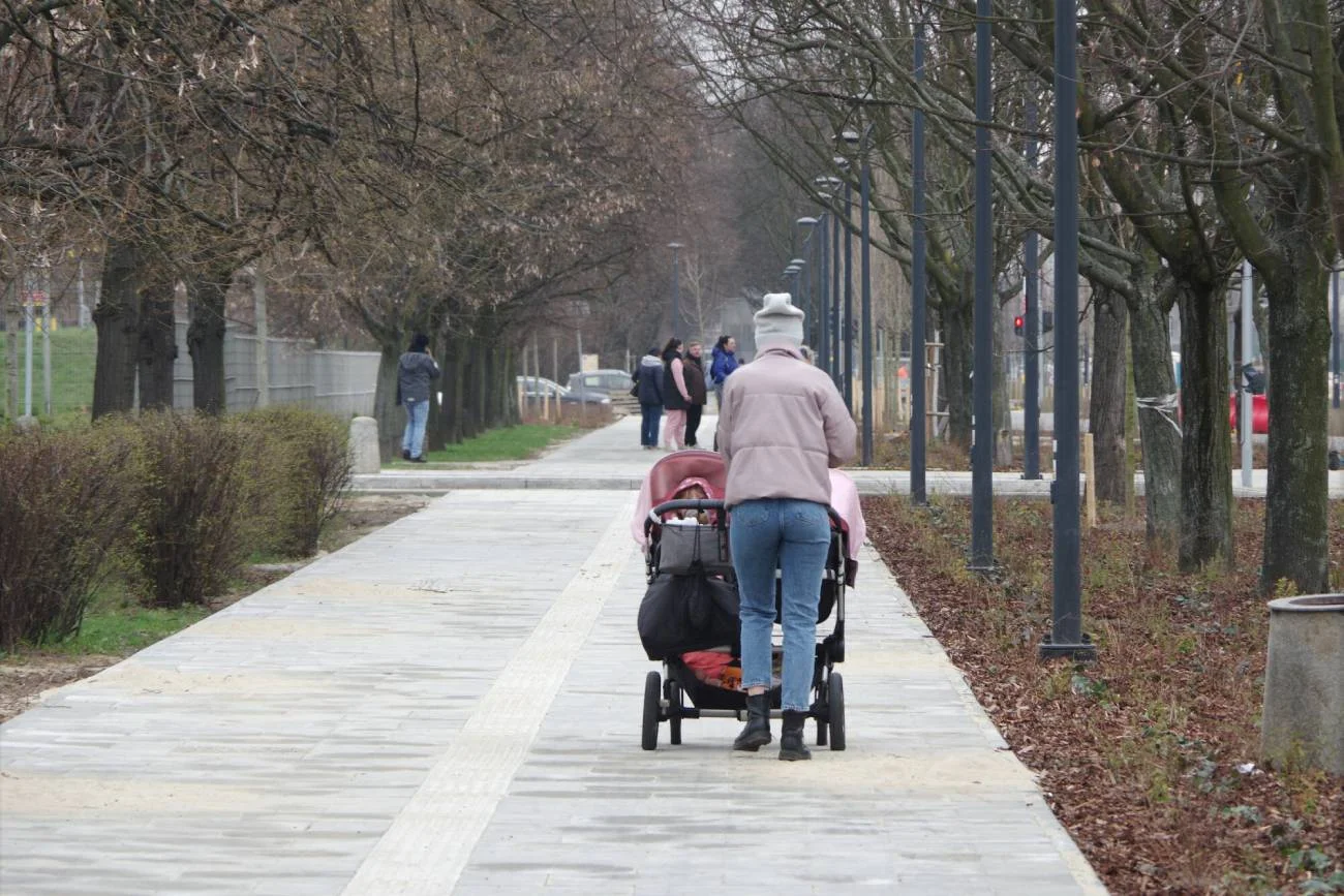 Kobieta z wózkiem na spacerze.