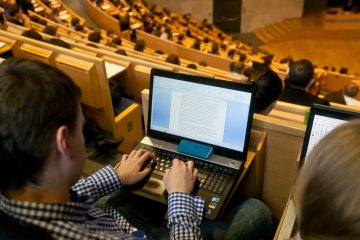 Student robi notatki na laptopie podczas wykładu. Student robi notatki na laptopie podczas wykładu.