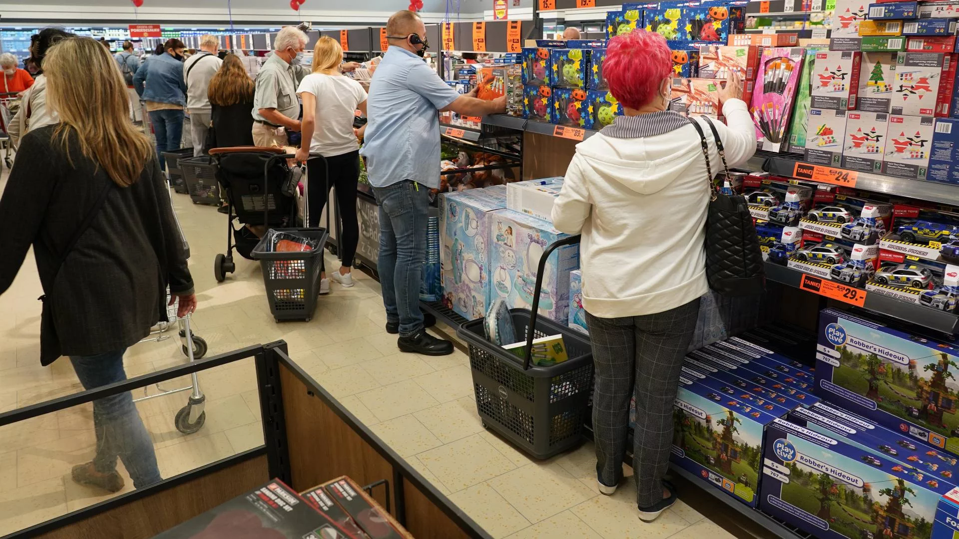 klienci przy sklepowych półkach w dyskoncie