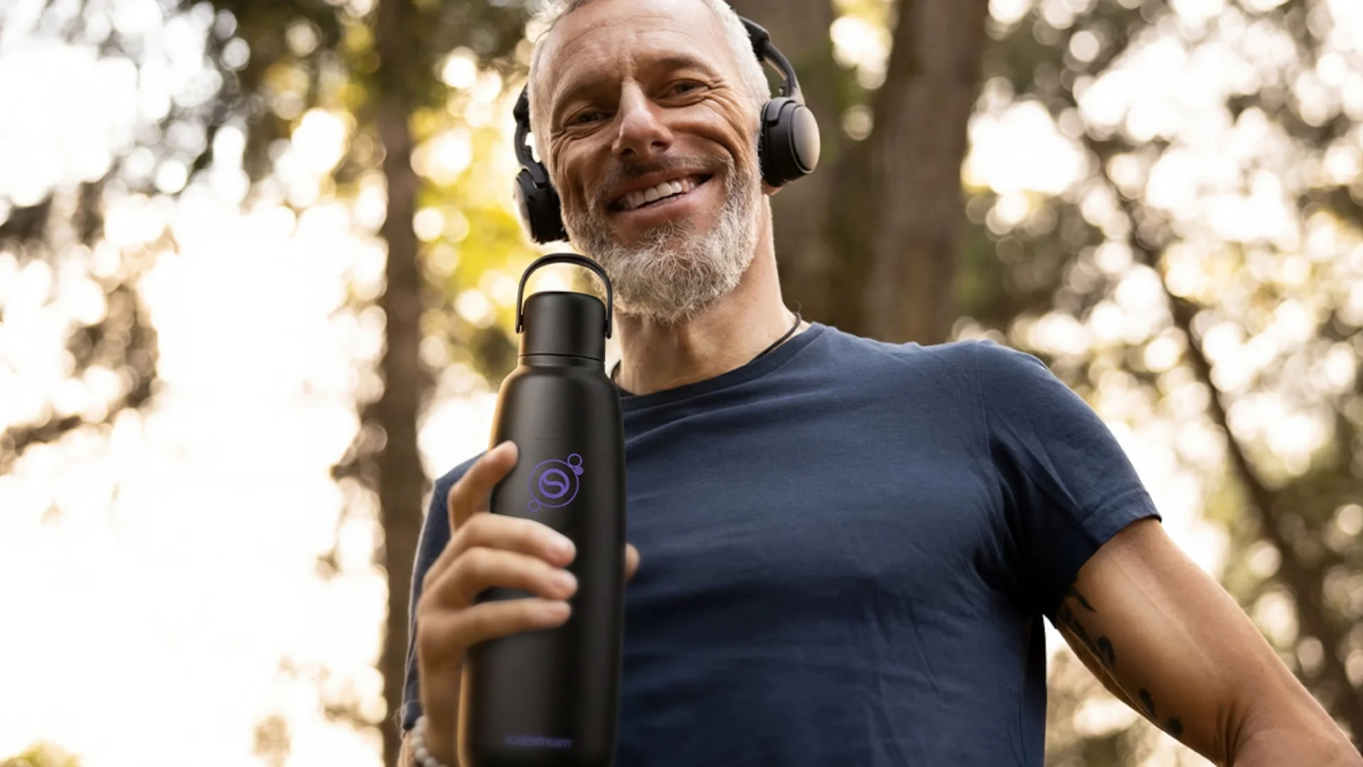 Uśmiechnięty mężczyzna podczas biegania z butelką Sodastream - tytułowa.