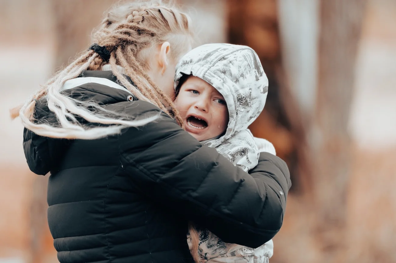 płaczące dziecko w objęciach mamy