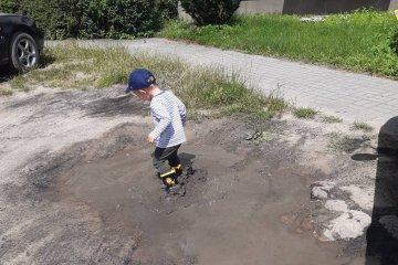 Mały chłopiec skacze po kałużach