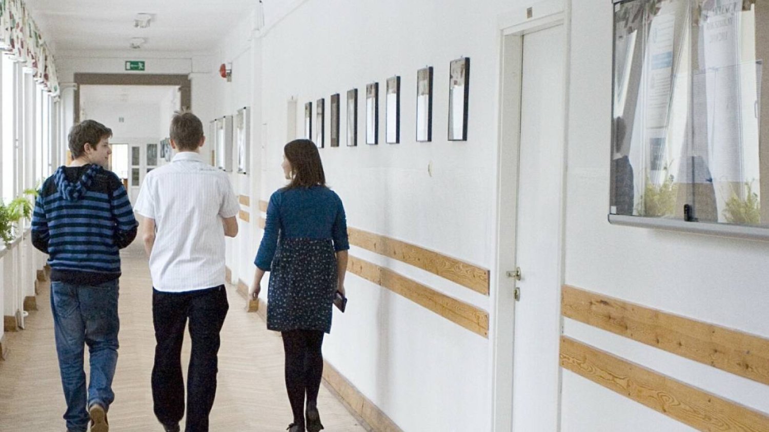Uczniowie idą szkolnym korytarzem Uczniowie idą szkolnym korytarzem