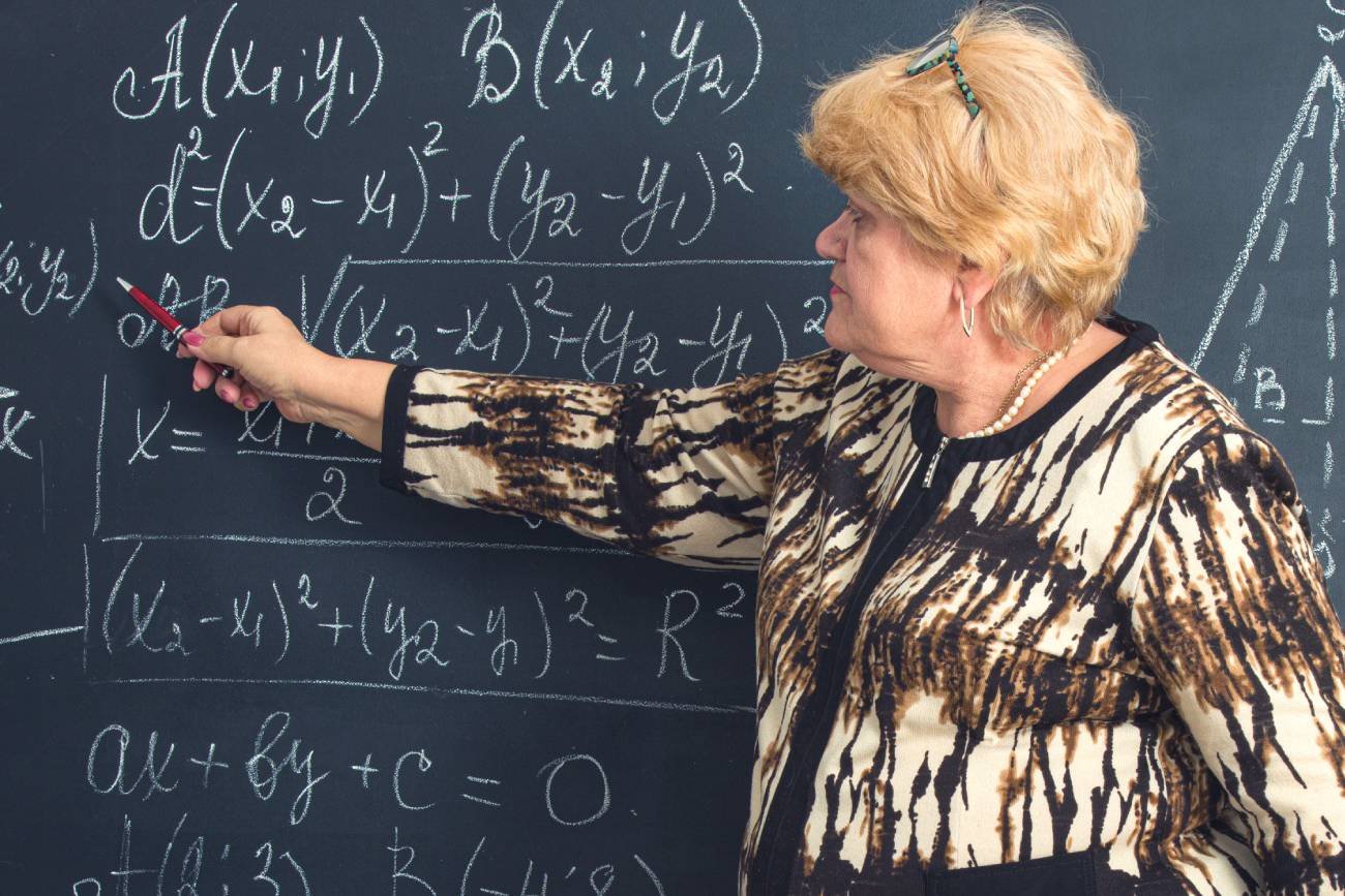 Nauczycielka matematyki pisze na tablicy.