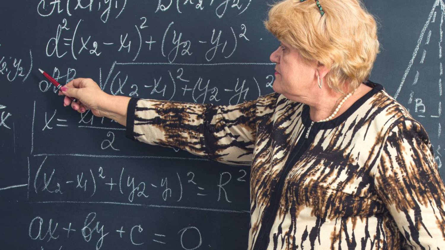 Nauczycielka matematyki pisze na tablicy. Nauczycielka matematyki pisze na tablicy.