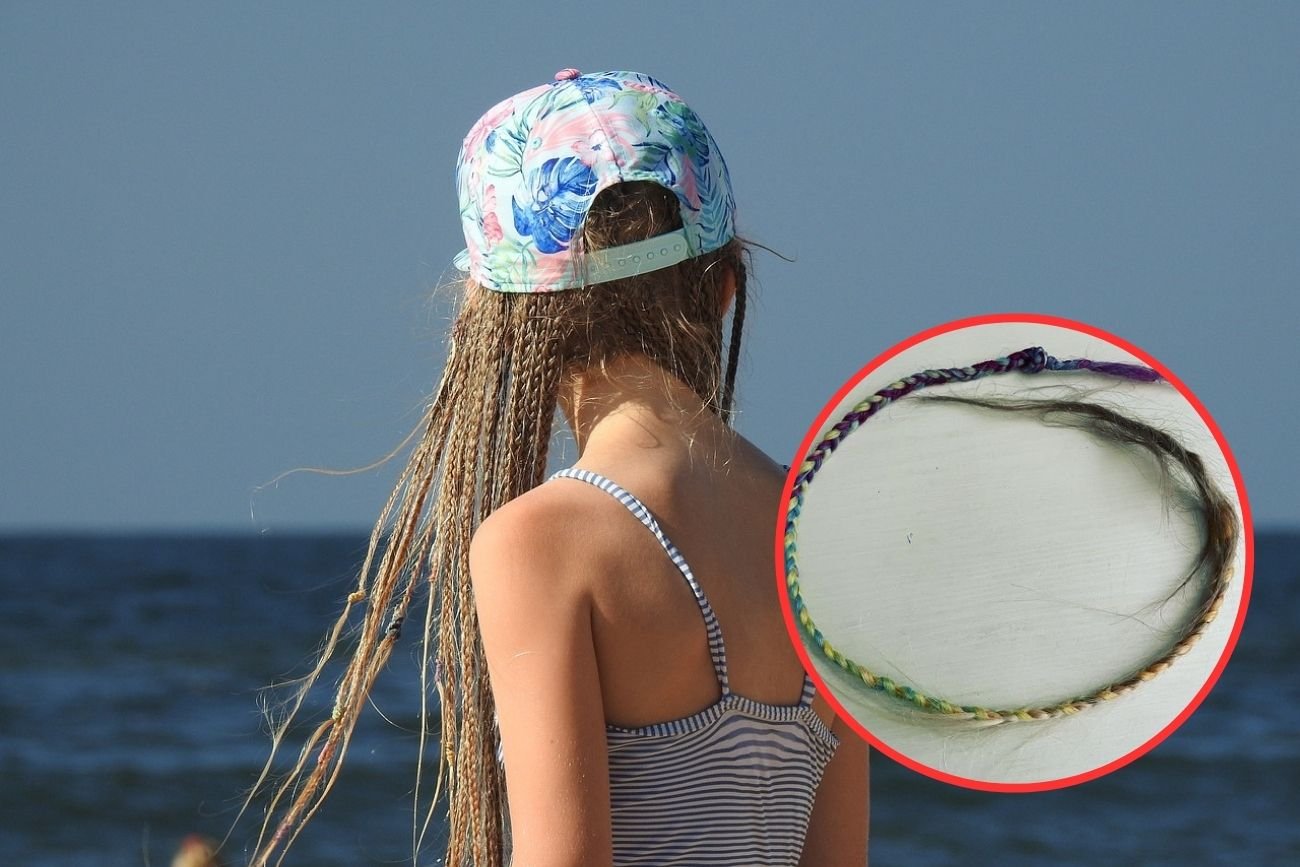 Dziewczynka na wakacjach nad morzem z warkoczykami na głowie.