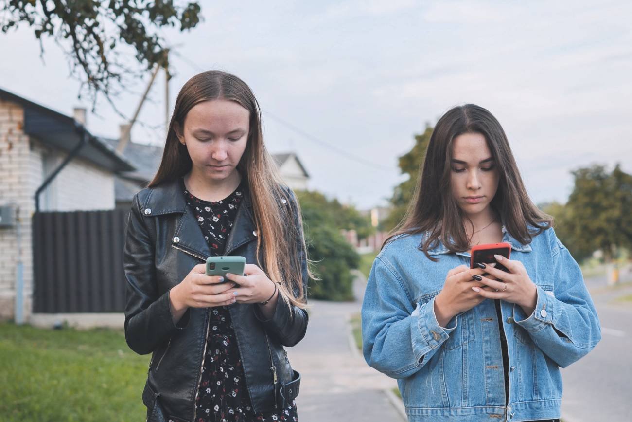 Nastolatki wpatrzone w swoje telefony.